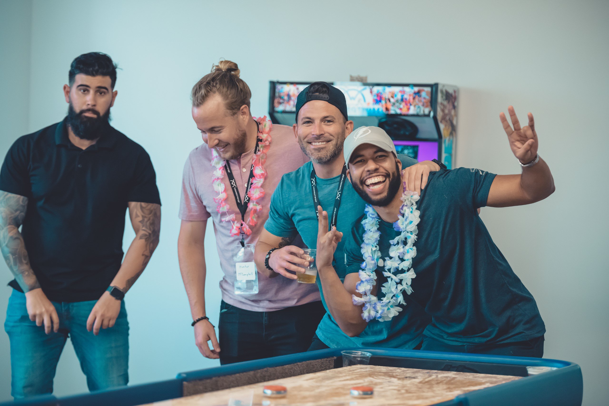 Four guys having fun around a foosball table