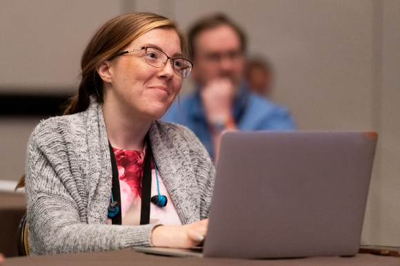 A woman with a laptop, attending IT Nation Secure