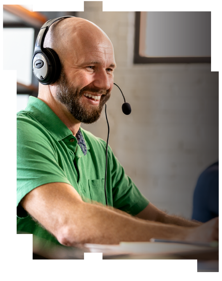 A smiling man wearing a headset and a green shirt