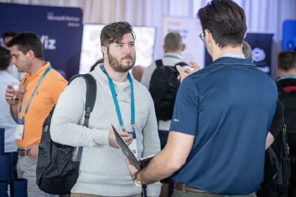 two conference attendees speaking to each other amidst crowd of people